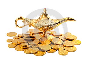 Grant a wish, desiring financial wealth with a old golden magic lamp on gold coins isolated on white background with clipping path photo
