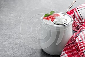 Granular cottage cheese with cream and berry jam on gray background photo