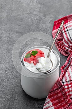 Granular cottage cheese with cream and berry jam on gray background photo