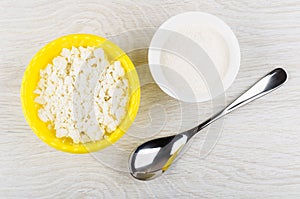 Granular cottage cheese in bowl, sugar in bowl, spoon