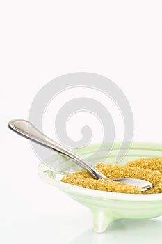 Granular raw sugar in bowl with copy space.