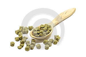 Granulated green hops in a wooden spoon