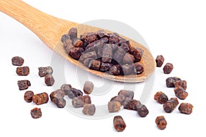 Granules of bee bread in a wooden spoon are on a white background. Apitherapy. Beekeeping products