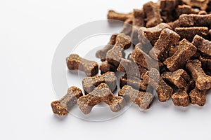 Granules of dry feed in the shape of a bone. for dogs on a white background