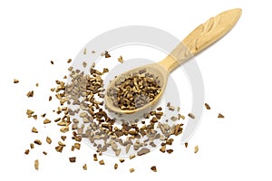 Granules of instant coffee in a wooden spoon