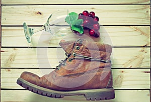 Grape and glass and boots on wood back ground.effcet vintage sty