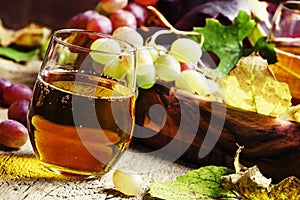 Grape juice in glass, autumn still life, vintage wooden background, selective focus