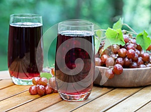 Grape juice in glasses with grapes in basket