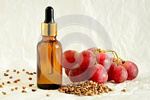 Grape seed oil in a bottle with dropper on white background close up.