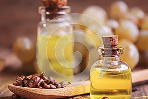 Grape seed oil in glass jar on wooden background. Selective focus