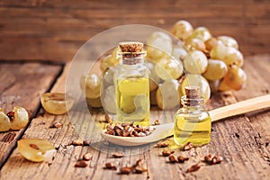 Grape seed oil in glass jar on wooden background. Selective focus