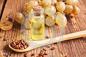 Grape seed oil in glass jar on wooden background. Selective focus