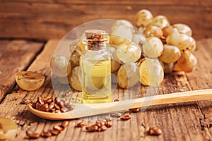 Grape seed oil in glass jar on wooden background. Selective focus