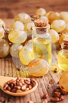 Grape seed oil in glass jar on wooden background. Selective focus