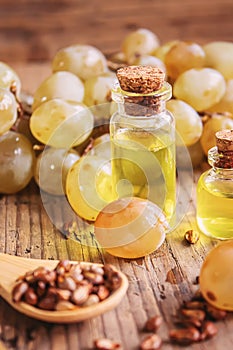 Grape seed oil in glass jar on wooden background. Selective focus