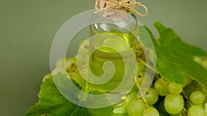 Grape seed oil on green background.Organic Natural Bio Grape Seed Oil. Glass bottle and bunch of green grapes with