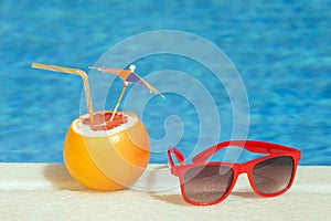 Grapefruit fresh juice drink and sunglasses at the poolside