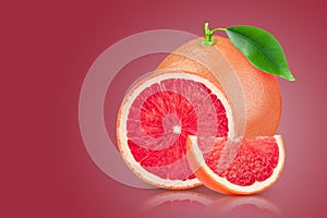 Grapefruit with leaf on red background. With clipping path. Full depth of field.