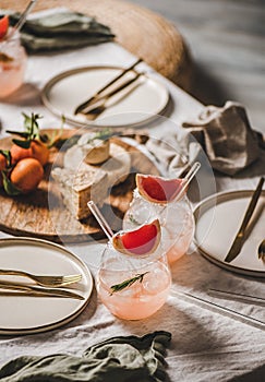 Grapefruit margaritas in glasses with straws, snacks for home party