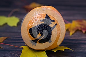 Grapefruit with a painted silhouette of a witch
