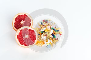 Grapefruit and pills, vitamin supplements on white background, healthy diet concept