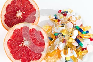 Grapefruit and pills, vitamin supplements on white background, healthy diet concept