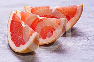 Grapefruit slices, juicy ripe on a gray background photo
