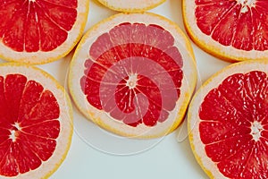 Grapefruit slices on the white background. Top view. Minimal colourful trend style. Copy space. Cut juicy slices. Tropical fruit