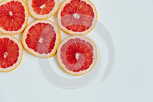 Grapefruit slices on the white background. Top view. Minimal colourful trend style. Copy space. Cut juicy slices. Tropical fruit