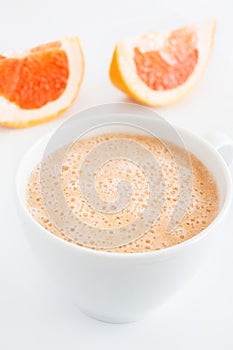 Grapefruit smoothie in white ceramic mug, closeup