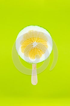 Grapefruit sweetie icecream with wood stick on light green background. Creative summe fruity popsicle sticks