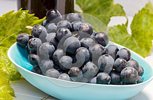 Grapes in a bowl with grape leaves
