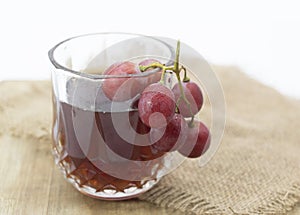grapes with cup of wine isolated on wooden background