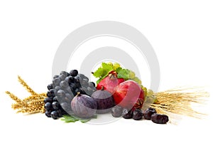Grapes, dates, figs, garnets, barley and wheat on a white background