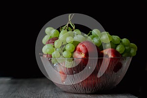 Grapes Nectarines in Dlass plate on a dark background. Still life photography high quality