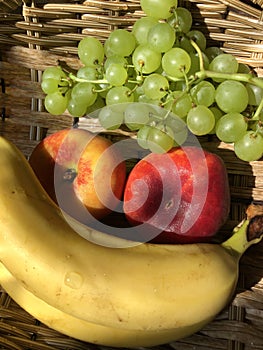 Grapes, peaches and bananas in a basket