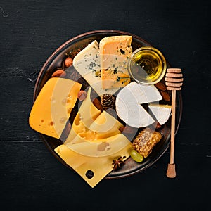 Grapes, red wine, cheeses, honey and nuts on a wooden background.