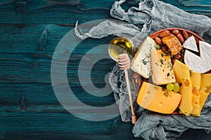 Grapes, red wine, cheeses, honey and nuts on a wooden background.