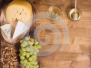 Grapes, white wine. honey and nuts over rustic wooden table