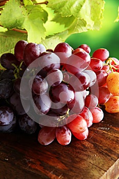 Grapes on wooden table and grape leaves . Healthy fresh fruit wine grapes.