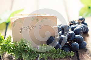 Grapes on a wooden table with a tag.