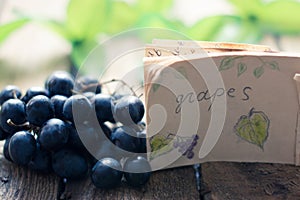 Grapes on a wooden table with a tag.