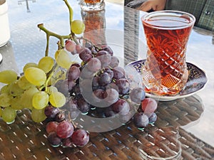 Grapevine next to a pear-shaped glass of tea during the daytime