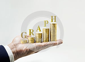 Graph word with money coin stacked growing on hand.