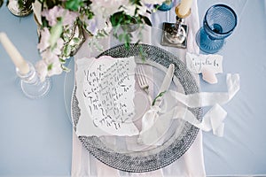 Graphic arts of beautiful wedding calligraphy cards and silver plate with cutlery.
