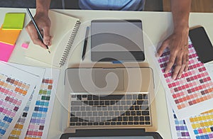 Graphic design and color swatches and pens on a desk.