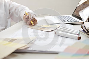 Graphic design and color swatches and pens on a desk. Architectural drawing with work tools and accessories.