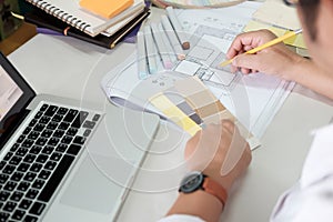 Graphic design and color swatches and pens on a desk. Architectural drawing with work tools and accessories.