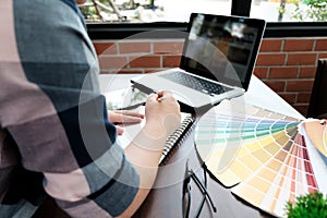 Graphic design and color swatches and pens on a desk. Architectural drawing with work tools and accessories.