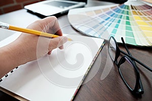 Graphic design and color swatches and pens on a desk. Architectural drawing with work tools and accessories.